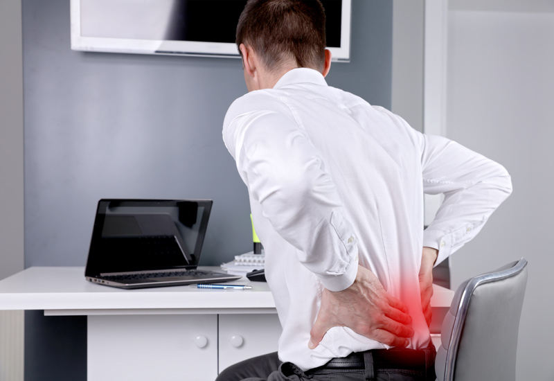 Business man suffering from back and neck pain in an office. Incorrect sitting posture problems, Muscle spasm, rheumatism. Pain relief, chiropractic concept